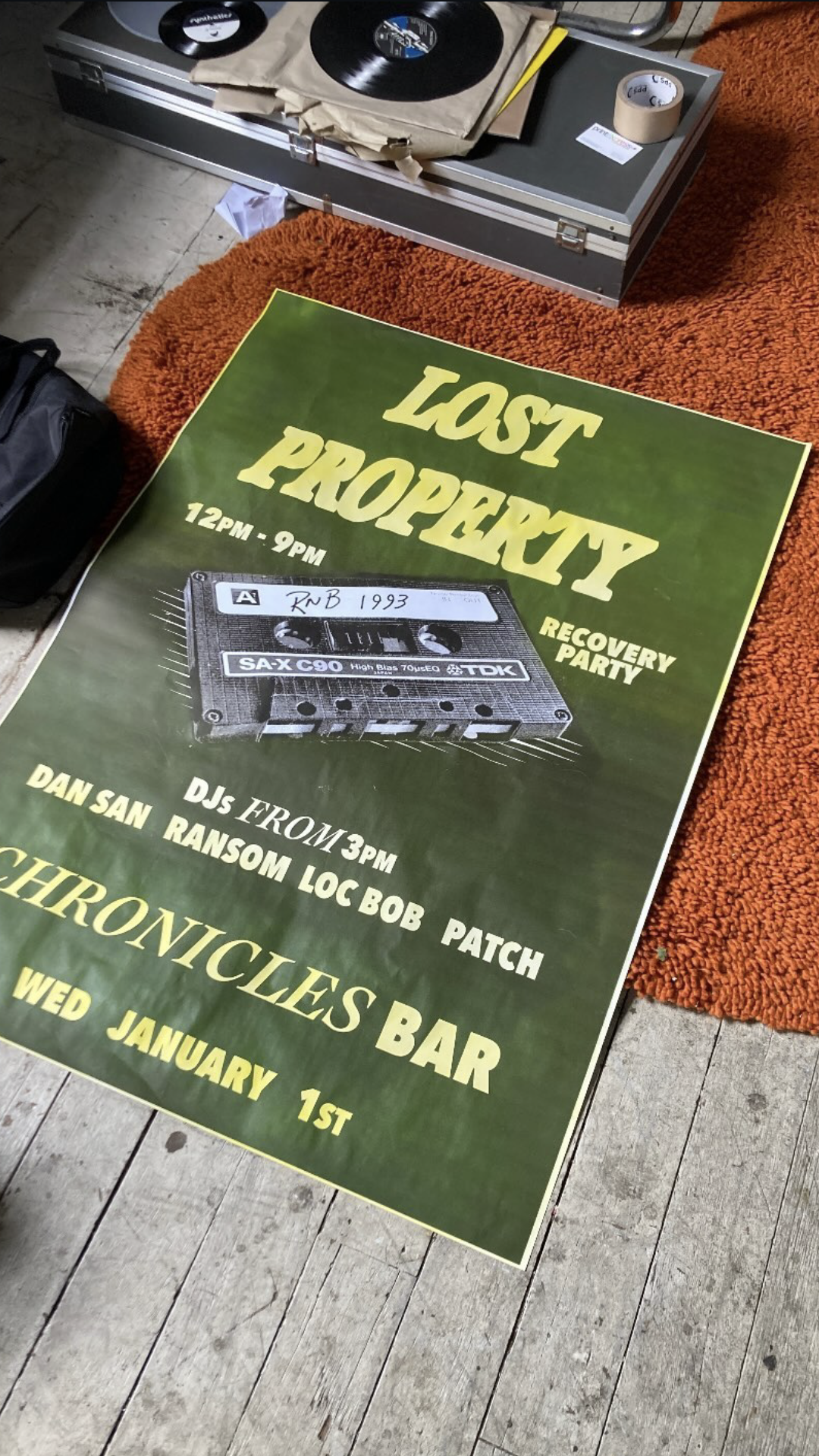 Chronicles Bar A0 Poster on display on the ground with turntables in the background.